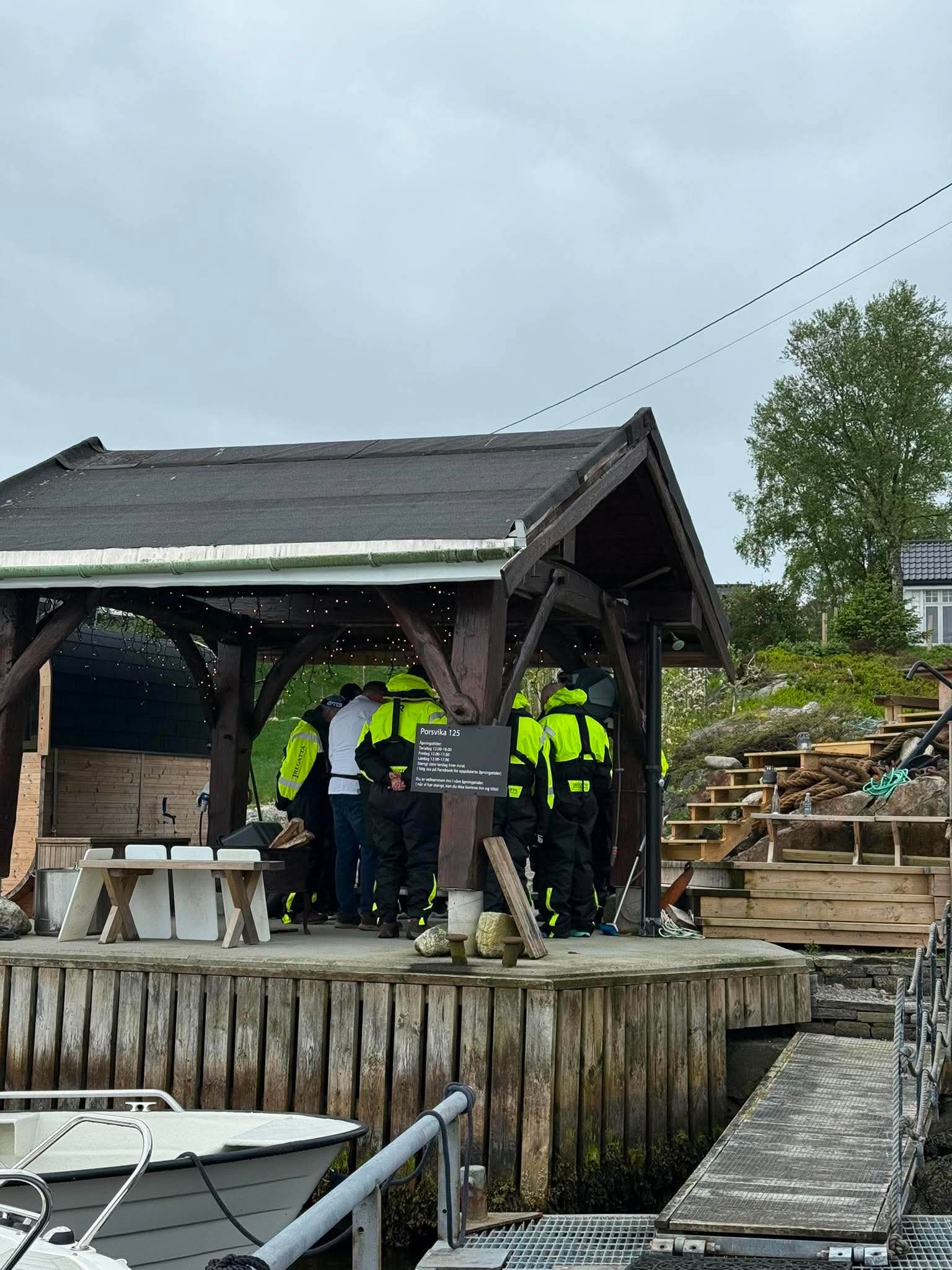 Group gathered around the seafood tasting at the water's edge